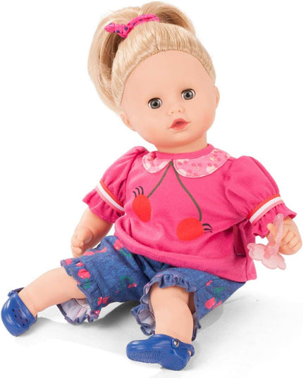 Doll wearing a pink outfit with red accents and blue shoes on a white background