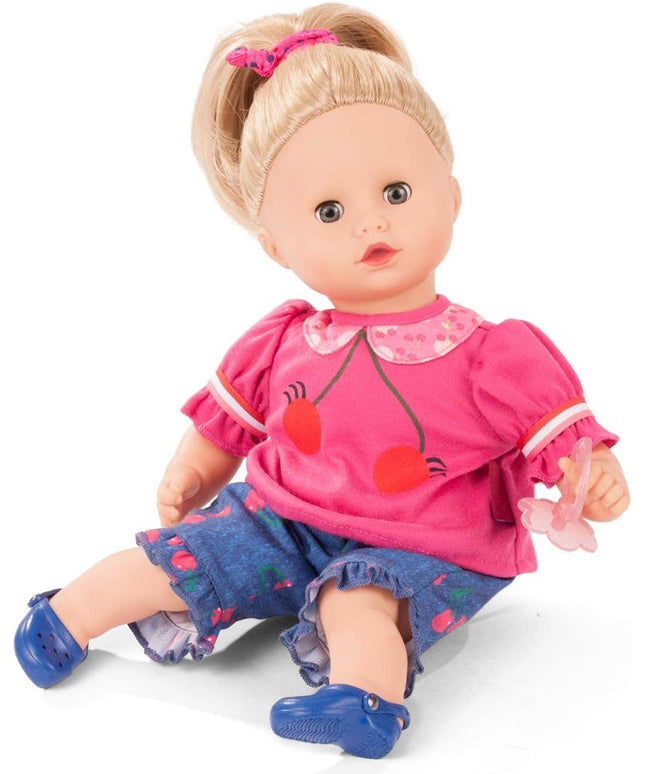 Doll wearing a pink outfit with red accents and blue shoes on a white background