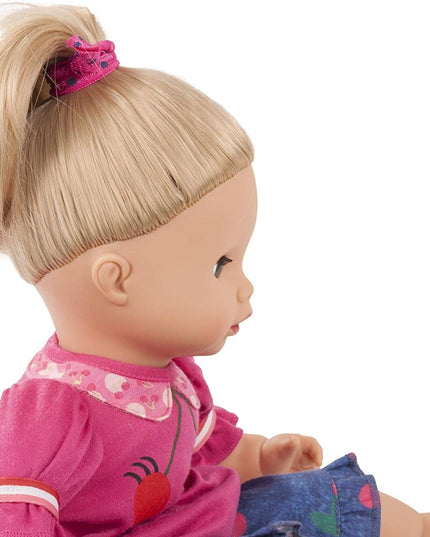 Close-up of a doll with blonde hair and pink outfit on a white background