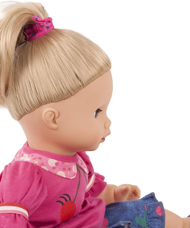 Close-up of a doll with blonde hair and pink outfit on a white background
