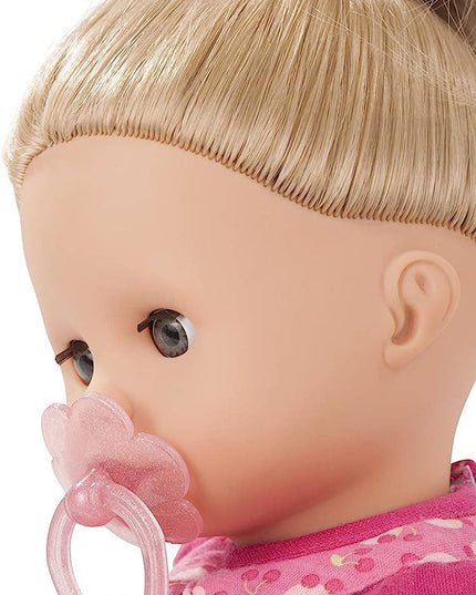 Close-up of a doll with blonde hair and pink pacifier