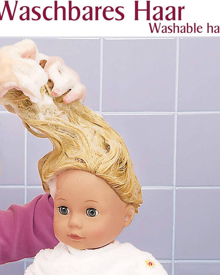 Person washing a doll's blonde hair with text indicating 'Waschbares Haar' (washable hair) on a tiled wall background.