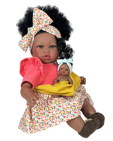 Doll holding a smaller doll with colorful outfit and headband on a white background