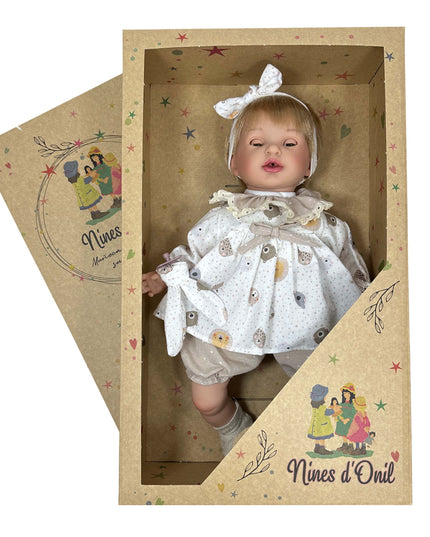 Baby doll in a decorative box with 'Nines d'Oril' branding