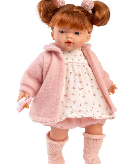Doll wearing a pink coat and dress with a white background