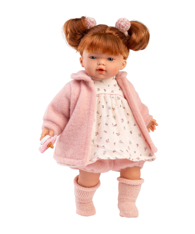 Doll wearing a pink coat and dress with a white background