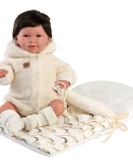 Baby doll in a white outfit with a blanket on a white background