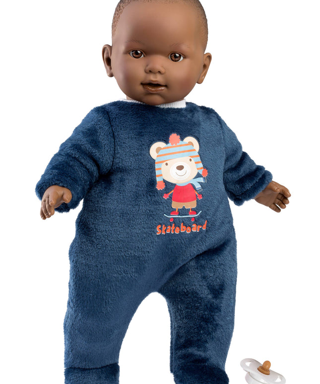 Baby doll wearing a blue onesie with a bear design on a white background