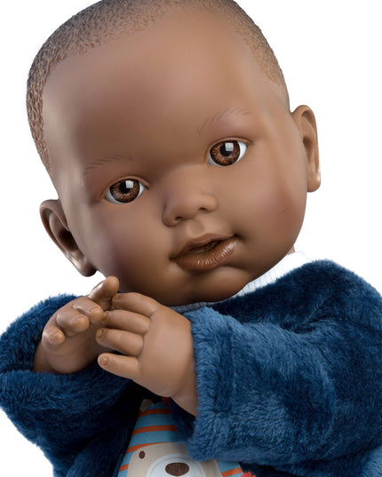 Doll of a baby wearing a blue outfit with a white background