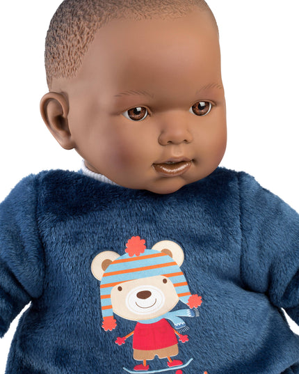 Baby doll wearing a blue fleece outfit with a bear design on a white background