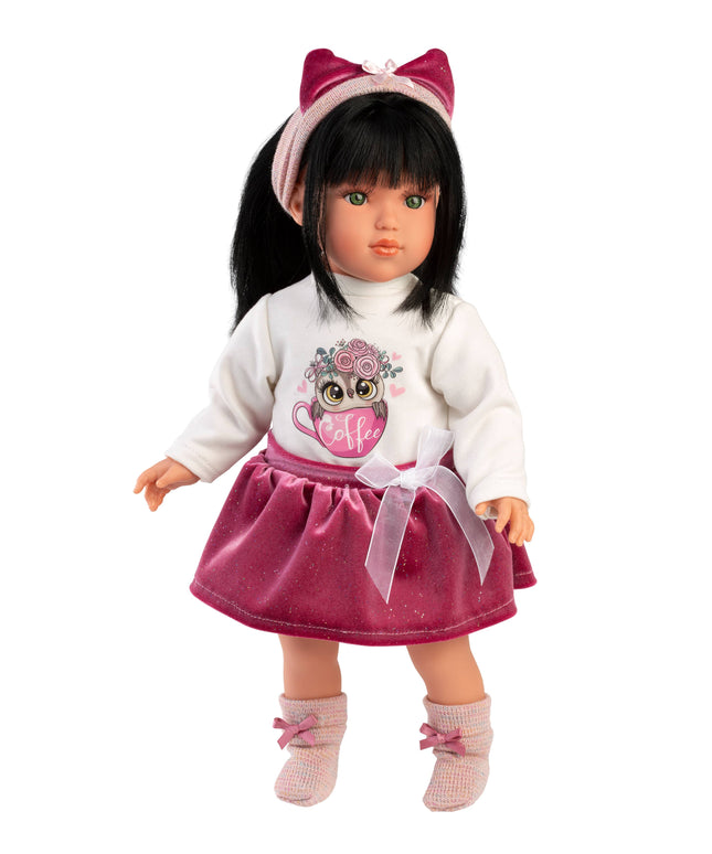 Doll wearing a white sweater with an owl design and a pink skirt on a white background
