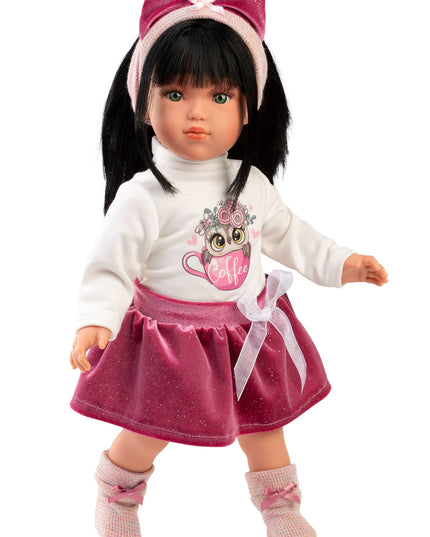 Doll with black hair, white sweater, pink skirt, and headband on a white background