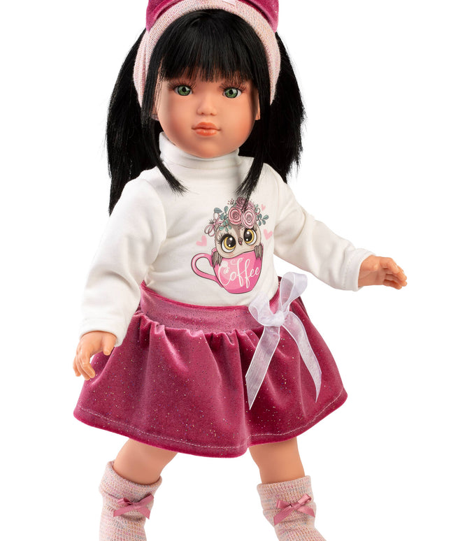 Doll with black hair, white sweater, pink skirt, and headband on a white background