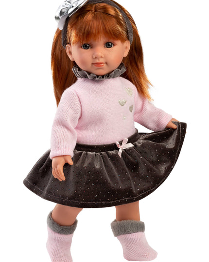 Doll wearing a pink sweater and black skirt with a white background