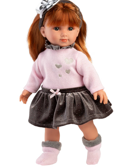 Doll with long brown hair wearing a pink sweater and gray skirt on a white background