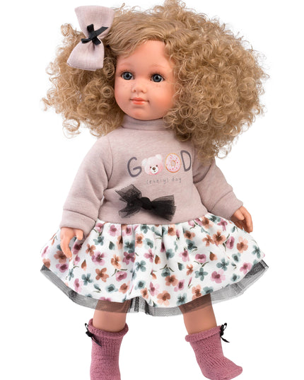 Doll with curly hair wearing a floral dress and gray sweater on a white background