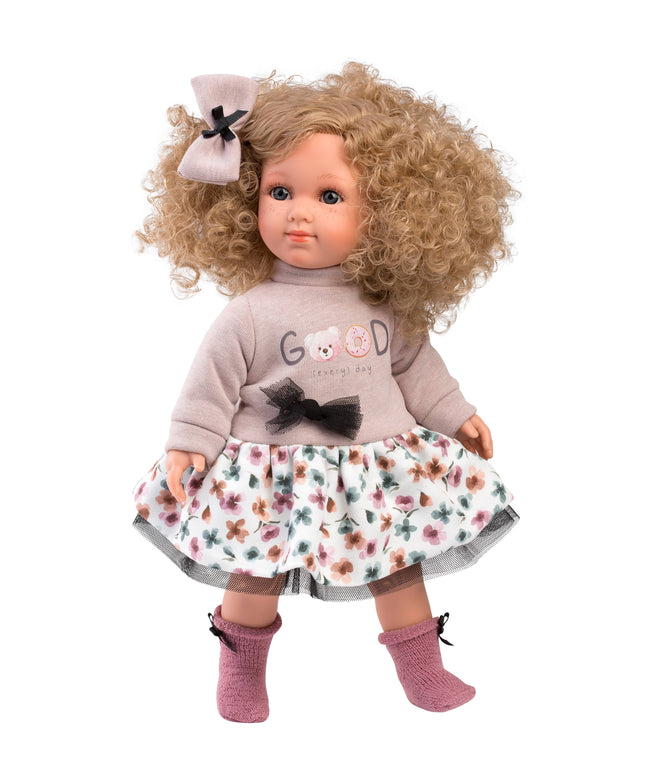 Doll with curly hair wearing a floral dress and gray sweater on a white background