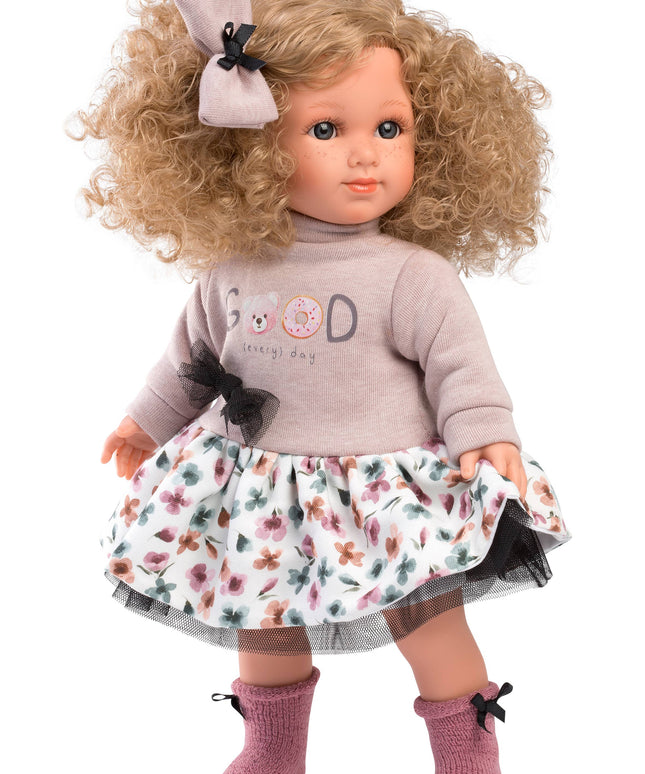 Doll with blonde hair, floral dress, and gray sweater on a white background