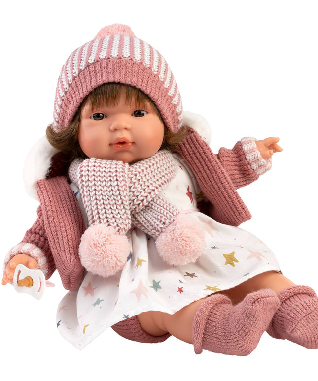 Doll wearing a pink outfit with a hat, scarf, and gloves on a white background