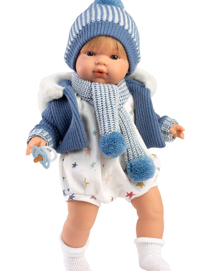 Baby doll wearing a blue outfit with a hat and scarf on a white background