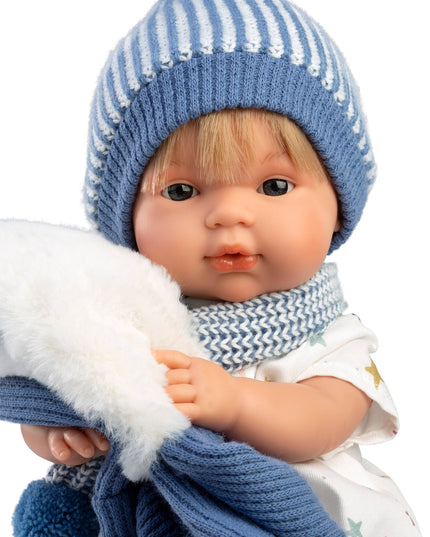 Doll wearing a blue knitted hat and scarf on a white background