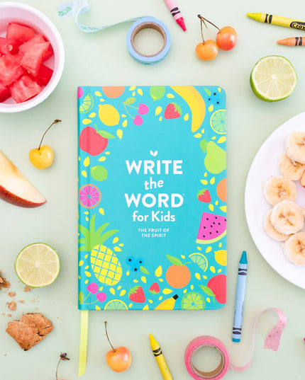 Notebook titled 'Write the Word for Kids' surrounded by fruits, crayons, and snacks on a light green background