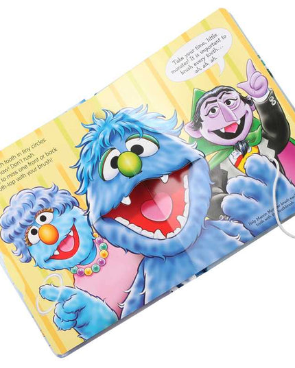 Children's book with Sesame Street characters and a toothbrush on a white background