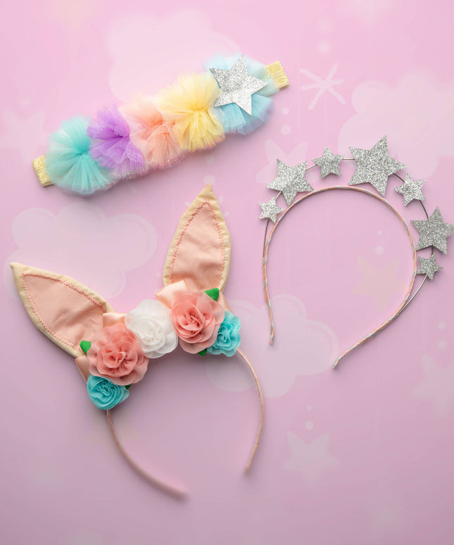Colorful headbands with floral and star designs on a pink background