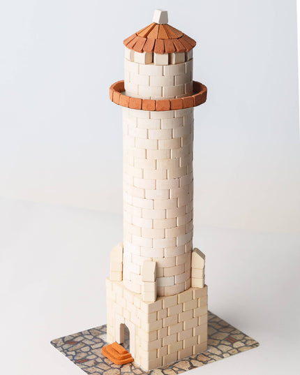 Model of a lighthouse made from interlocking bricks on a white background