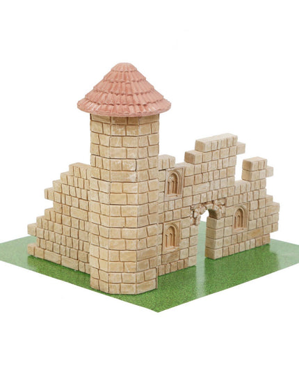 Model of a castle made from interlocking bricks on a green base with a white background