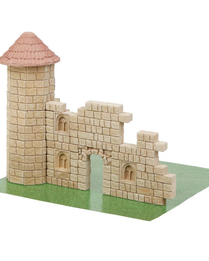Model of a castle made from interlocking bricks on a green base.