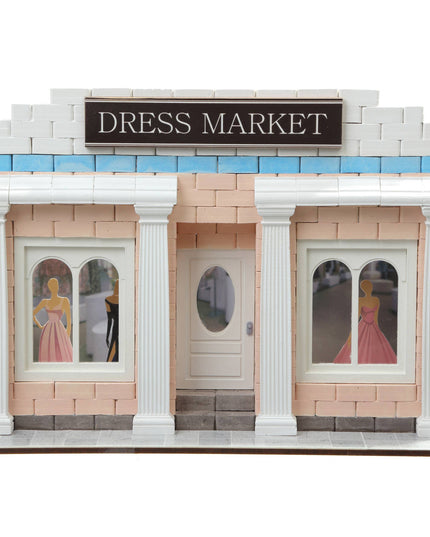 Model of a dress market building with a sign and windows displaying dresses.