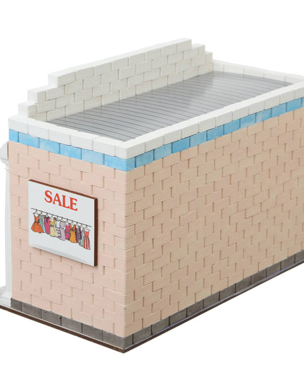 Model of a store front with a 'Sale' sign made from interlocking bricks on a white background