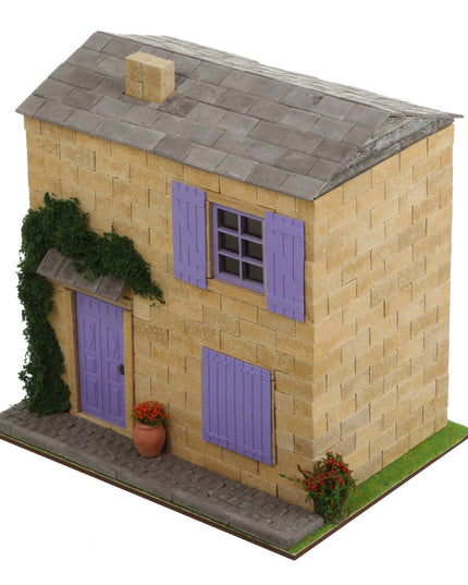 Model of a two-story house with purple shutters and a gray roof on a white background