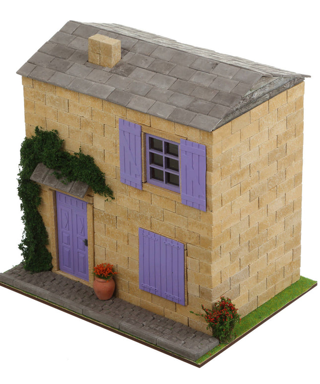 Model of a two-story house with purple shutters and a gray roof on a white background