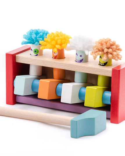 Colorful toy hammer set with wooden blocks and head attachments on a white background
