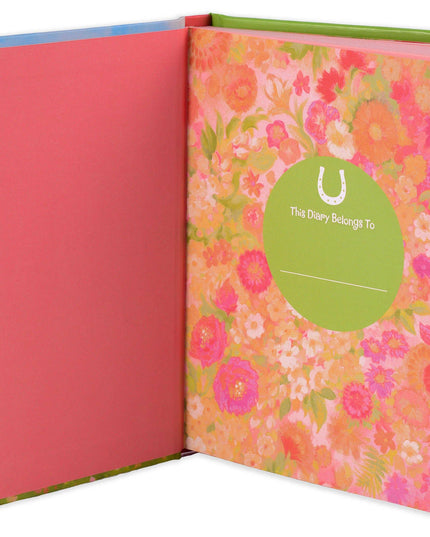 Floral notebook with a pink cover and green binding, featuring a visible brand logo.