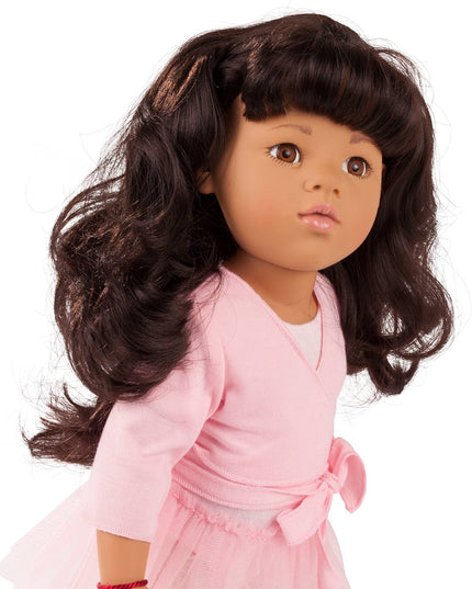 Doll with long dark hair wearing a pink outfit on a white background