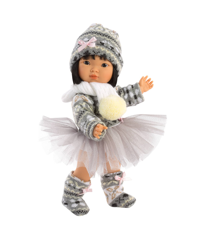 Doll wearing a winter outfit with a hat, scarf, and skirt on a white background