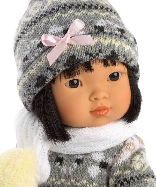 Doll wearing a gray knitted hat with a pink bow and matching outfit on a white background