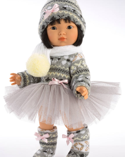 Doll wearing a gray knitted outfit with a white scarf and tulle skirt on a white background