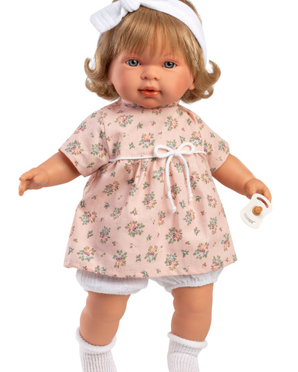 Doll wearing a floral dress with a white headband on a white background