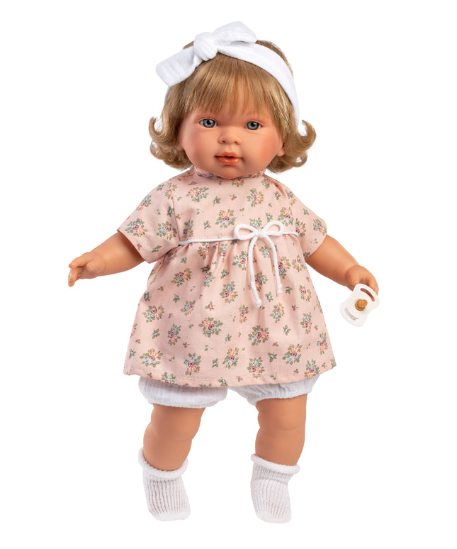 Doll wearing a floral dress with a white headband on a white background