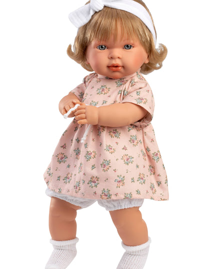 Doll wearing a floral dress with a white headband on a white background