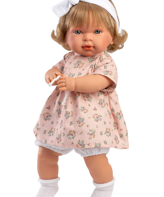 Doll wearing a floral dress with a white headband on a white background
