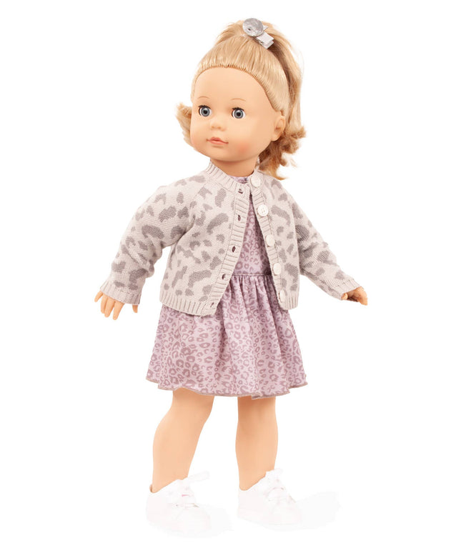 Doll wearing a patterned cardigan and dress on a white background