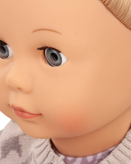 Close-up of a doll with detailed facial features and a textured sweater.