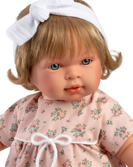 Doll with blonde hair and a floral dress on a white background