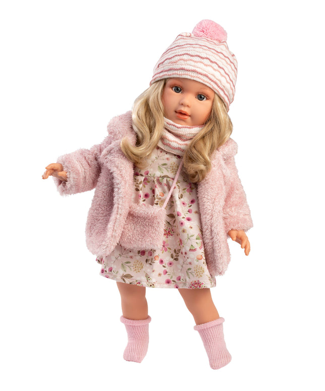 Doll wearing a pink outfit with a coat, dress, hat, and bag on a white background
