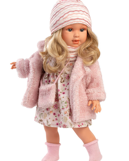Doll wearing a pink coat, floral dress, and striped hat on a white background